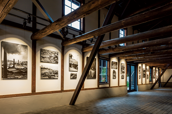 向かって左手は2階の床がのぞかれ、勇壮な小屋組みが見上げられる。1階のギャラリーでは山田脩二さんの写真「やきものの町 常滑」を常設展示。